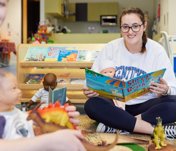 Person sitting in a childcare reading a book 