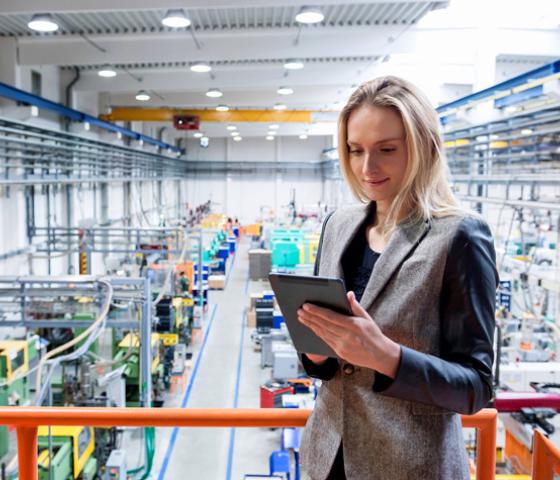 Image of a person in a factory looking at an ipad 