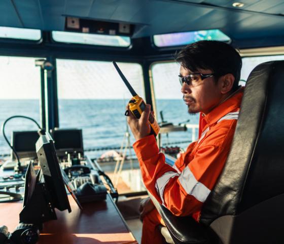 image of person on ship's bridge operating radio