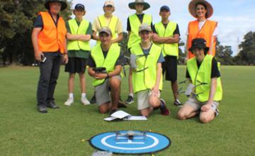 Remote Pilot class standing in a group operating a drone