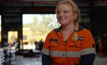 South Metro TAFE student Josie Daintith in the heavy auto workshop smiling 